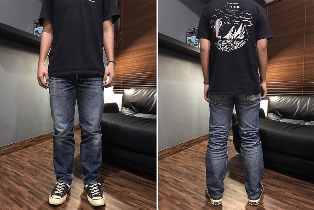 A person with a graphic tee wearing faded selvedge denim jeans