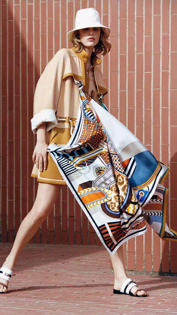A model with a Hermes silk scarf draped over her.